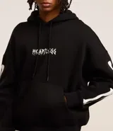 Buzo negro de fleece con felpa, corte boxy, capucha con cordón ajustable, manga larga, estampa lettering frontal, bolsillo canguro, patch de esqueleto en la manga y puños ajustados.