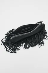 Bandolera marrón de serraje con flecos largos en la parte inferior. Tiene asa de hombro y bandolera extraíbles, doble bolsillo interior y cierre con cremallera.
