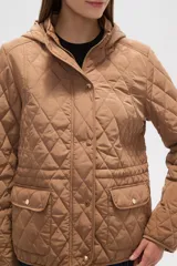 Campera blanca con diseño acolchado, cierre frontal con botones a presión y capucha desmontable.