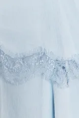 Top celeste con breteles finos, escote en V y doble capa de tela con detalle de encaje a tono.