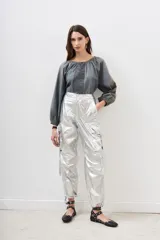 Pantalón plateado metalizado de corte holgado con bolsillos laterales y lazo en la cintura.