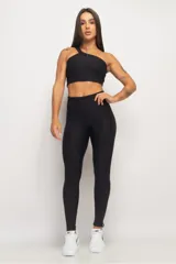 Top deportivo negro de un solo hombro, con textura acanalada y calce ajustado.