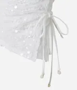 Top sin breteles de lentejuelas color blanco, con escote recto y lazo fruncido en el lateral.