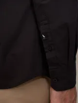 Camisa blanca de manga larga, confeccionada en algodón.