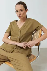 Remera verde oliva con escote en V, manga corta con dobladillo y cierre frontal con botones.