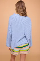 Buzo color crema tejido en algodón, de silueta holgada, mangas anchas y cuello bote.