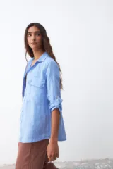 Camisa celeste de lino con mangas 3/4 y dos bolsillos frontales.