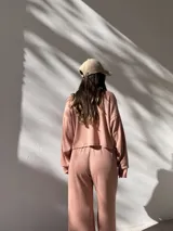 Conjunto deportivo color rosa compuesto por un buzo de cuello alto y mangas largas, y un pantalón palazzo con cintura elastizada y cordón ajustable.