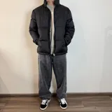 Campera puffer color beige con cierre frontal y cuello alto.