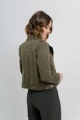 Chaqueta color beige de tela tipo gamuza con elastano, cuello solapa, manga larga con trabillas en hombro, bolsillos delanteros con cremallera metálica y cierre frontal con cremallera.