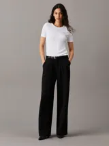 Pantalón negro de crepé elástico, corte recto, cintura plisada, bragueta con cremallera y bolsillos con ranura.
