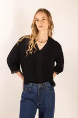 Blusa negra con detalles de bordado en el escote y mangas cortas abullonadas.