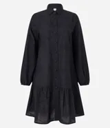 Vestido corto estilo camisa confeccionado en laise negro con bordado floral, cuello inglés, mangas largas abullonadas con puños elásticos y volado en el bajo. Cierre frontal con botones.