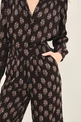 Pantalón capri negro con estampado floral, corte regular, bolsillos laterales y elástico en la parte trasera de la cintura.