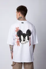 Remera blanca de algodón de corte oversize con mangas cortas y cuello redondo. Presenta un pequeño estampado en el frente con la figura de Mickey Mouse y caracteres orientales.
