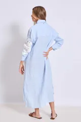 Vestido camisero celeste de lino con apliques de encaje blanco en cuello, mangas y frente.