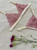 Conjunto de lencería color rosa champagne, con corpiño triangular de encaje y tanga a juego con detalles de encaje.