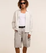 Bermuda masculina de jean color gris oscuro, corte holgado, con bolsillos cargo laterales, trabillas en la cintura y cierre con botón y cremallera.