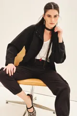 Campera negra con jareta ajustable en el ruedo con cordón de colores, presilla interna en las mangas y bolsillos en el delantero.