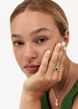 Anillo de plata 925 con una piedra de zirconia verde central rodeada de zirconias brillantes.