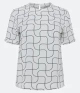 Blusa blanca estampada con líneas geométricas negras, de mangas cortas con dobladillo, cuello redondo y abertura en la espalda con botón.