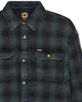 Camisa de franela a cuadros en tonos beige, gris y negro. Tiene cuello clásico, cierre con botones, dos bolsillos con solapa en el pecho y puños abotonados.