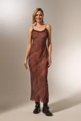 Vestido midi de poliéster con estampado animal print, breteles finos y volados en el escote. Corte al cuerpo y cuello redondo.