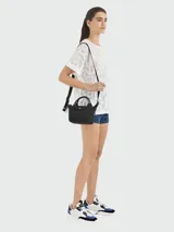 Bolso negro de cuero, tipo bandolera, con doble asa corta y correa larga ajustable y extraíble.
