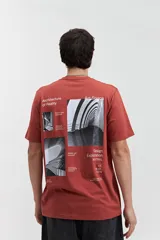 Remera celeste de manga corta con cuello redondo y estampado en la espalda con imágenes de arquitectura y texto.