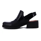 Zueco negro con hebilla plateada, taco ancho y suela track.