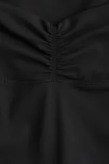 Calzas de yoga acampanadas negras, de tiro alto con cintura ancha con detalle fruncido adelante. Confeccionadas en tejido funcional SoftMove™ con tecnología Lycra® Sport.