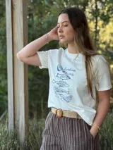 Pantalón de lino azul marino con rayas verticales blancas, corte palazzo, cintura alta con elástico y cinturón de raffia con hebilla redonda.