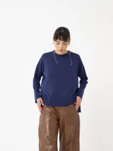 Sweater de punto fino color azul marino, con cuello redondo y manga larga, confeccionado en tejido suave y liviano.