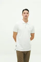 Polo color beige con textura, corte regular, logo estampado en el pecho y mangas cortas con ribete blanco.