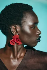 Par de aros metálicos con forma de flor en relieve color rojo. Cierre con tuerca y clip.