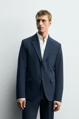 Blazer slim fit azul marino confeccionado en tejido con viscosa. Cuello con solapas de muesca, manga larga con puño abotonado, bolsillo de vivo en pecho y de solapa en cadera, bolsillo interior, bajo con aberturas en espalda y cierre frontal con botones.