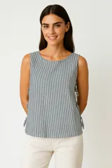 Blusa sin mangas con estampado a rayas verticales en tonos blanco, azul y verde. Presenta cuello redondo y lazos laterales.