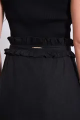 Falda corta de color marrón con detalle de volados en la cintura y corte recto.