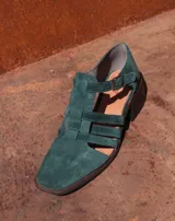 Sandalia de cuero combinada con gamuza color verde, con diseño de tiras cruzadas y tacón bajo.