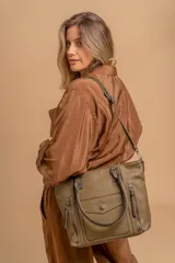 Cartera bandolera de símil cuero color marrón claro, con doble asa rígida y correa regulable. Presenta dos bolsillos frontales con cierre vertical y un bolsillo frontal con solapa y botón. Cuenta con dos divisiones internas.