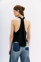 Musculosa blanca de algodón flameado, con escote en V pronunciado y espalda deportiva.