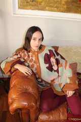 Cárdigan de punto con estampado floral en tonos celeste, verde, marrón y violeta. Tiene corte oversized y cierre frontal con botones.