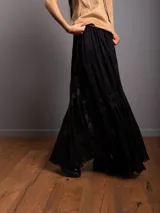 Pollera larga de encaje negro con volados y volumen en el bajo.