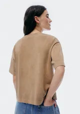 Remera color beige de corte recto, con cuello redondo y bolsillo en el pecho.