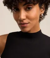 Musculosa negra de punto acanalado con cuello alto y tirantes anchos.