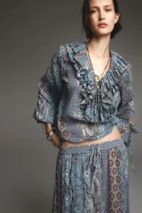 Camisa de manga larga con estampado cachemir en tonos celeste, azul y marrón. Presenta escote en V con volantes y lazos.