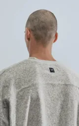 Sweater color beige, de corte holgado y mangas largas con detalle de puño ajustado.