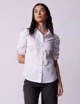 Camisa blanca de algodón, marca Zac & Rachel. Cuello a la base con solapa y escote en V. Abertura central con botones. Mangas 3/4 con frunce. Laterales en tejido modal.