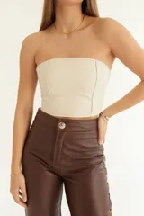 Pantalón de cuero marrón chocolate, de tiro alto, corte recto con leve flare y aberturas en el ruedo. Presenta costuras marcadas y trenzado lateral.