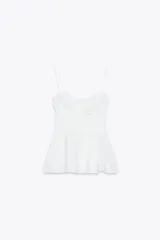 Top blanco de escote corazón y tirantes finos. Tiene corte peplum y cierre lateral con cremallera oculta.